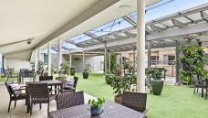 Bupa-Aged-Care-Mosman-outdoor-area-with-shade-and-chairs